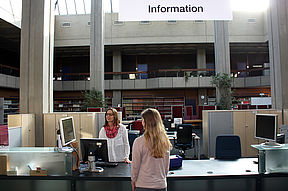Das Bild zeigt den Informationsschalter von der Uni-Bibliothek. Man sieht eine Mitarbeiterin, die einer bwin_bwinֹӭ@ etwas erkl?rt.