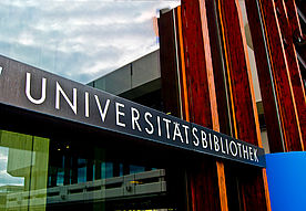 Das Bild zeigt das Schild ber dem Eingang von der Uni-Bibliothek. Darauf steht Universit?tsbibliothek.